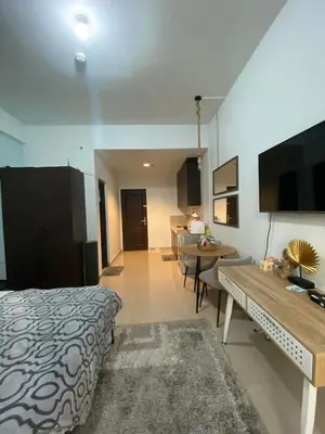 a room with a bed and a table and a television at Nature Inspired Affordable Rooms in F RESIDENCE near Edsa Shaw Pasig Megamall Shangrila and MRT in Manila