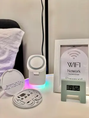 a table with a clock and a picture and a thermometer at Sunshine 100 Cozy Mandaluyong Studio Near BGC in Manila
