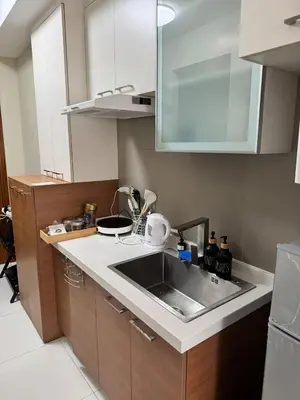 a kitchen with a sink and a microwave at Sunshine 100 Cozy Mandaluyong Studio Near BGC in Manila