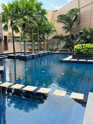a swimming pool with chairs in the middle of a building at Sunshine 100 Cozy Mandaluyong Studio Near BGC in Manila
