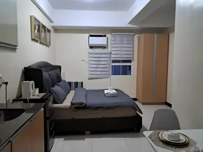 a small room with a bed and a kitchen at 101 Newport Boulevard-Hyuna Place, Across NAIA T3 in Manila