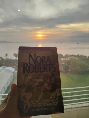 a person holding a book in front of a window at Chic Haven in Manila