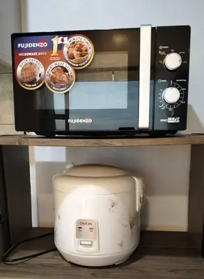 a microwave and a toaster oven on a shelf at Chic Haven in Manila