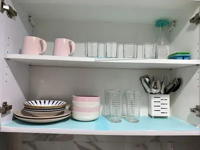 a shelf with plates and cups and glasses on it at Executive Suite Air Residence Style Comfort Makati 300 Mbps in Manila