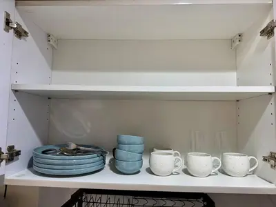 a shelf with blue plates and cups on it at Executive Suite Air Residence Style Comfort Makati 300 Mbps in Manila