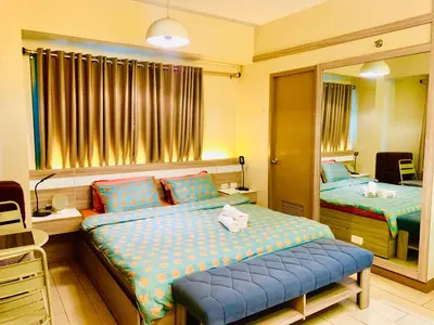 a bedroom with two beds and a mirror at Across NAIA terminal 3 in Manila