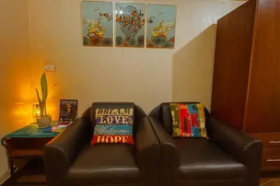 a brown leather chair with two pillows on it at La Verti Residences Unit 1420 I Skyline Views & Luxe Stay Near MOA in Manila