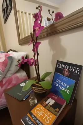 a table with two books and a flower on it at La Verti Residences Unit 1420 I Skyline Views & Luxe Stay Near MOA in Manila