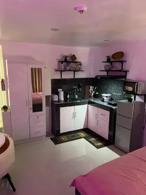 a kitchen with purple walls and white cabinets at Modern Studio near MOA, Airport & Heart of Pasay in Manila