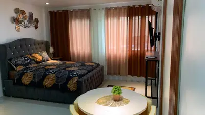 a living room with a couch and a table with a cactus at Modern Studio near MOA, Airport & Heart of Pasay in Manila