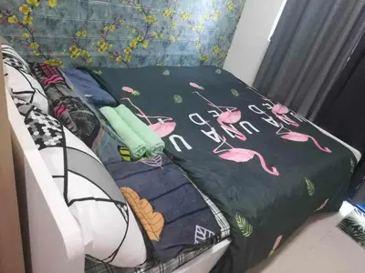 a bed with a black blanket with pink flamingos on it at Bini Comfort room in Manila