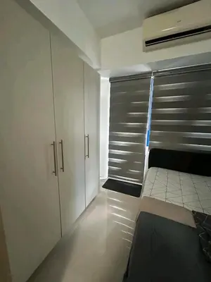 a bedroom with white cabinets and a bed in it at Bini Comfort room in Manila