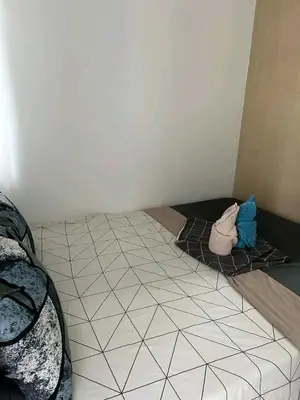 a bed in a room with a tiled floor at Bini Comfort room in Manila