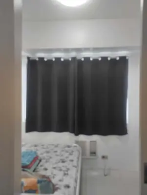 a bedroom with a black curtain and a bed at Bini Comfort room in Manila