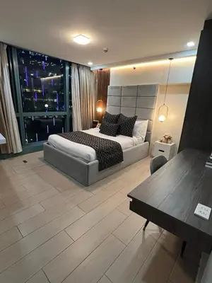 a bedroom with a bed and a table and a window at LARGE One Bedroom Unit In Uptown BGC in Manila