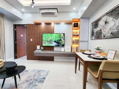 a living room with a television on a wall at LARGE One Bedroom Unit In Uptown BGC in Manila