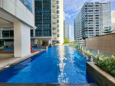 a swimming pool in a city with tall buildings at LARGE One Bedroom Unit In Uptown BGC in Manila