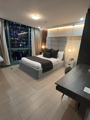 a large bedroom with a bed and a table in it at LARGE One Bedroom Unit In Uptown BGC in Manila