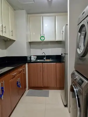 a kitchen with a sink and a washing machine at Cozy Jen 150newport Boulevard condotel in Manila