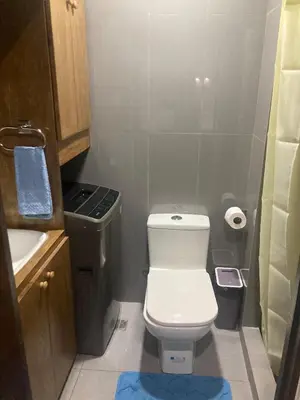 a small bathroom with a toilet and a sink at Rustic condo in Makati CBD in Manila
