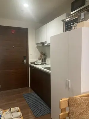 a kitchen with a door leading into a kitchen with a sink at Rustic condo in Makati CBD in Manila