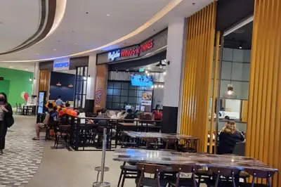 a restaurant with tables and people sitting at tables at Rustic condo in Makati CBD in Manila