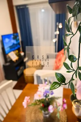 a living room with a table with flowers on it at CASA Salcedo - Field Residences in Manila