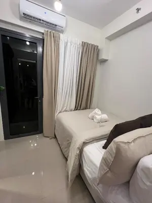 a hotel room with two beds and a window at Snuggle Suites in Manila