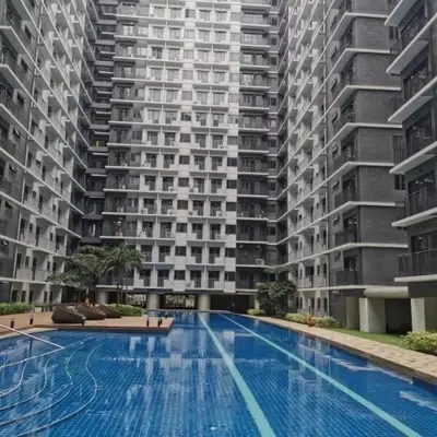 a large apartment building with a large swimming pool at Snuggle Suites in Manila