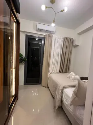 a small bedroom with a bed and a window at Snuggle Suites in Manila