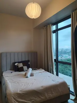 a bedroom with a large bed with a large window at Near MOA 3 pax unit in Gentry Manor in Manila