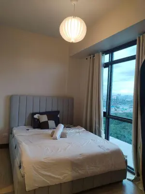 a bedroom with a large bed with a large window at Near MOA 3 pax unit in Gentry Manor in Manila