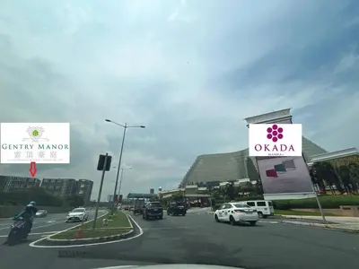 a street with cars driving down a road with signs at Moa Gentry Manor WIFI TV Balcony with view Beside Okada in Manila