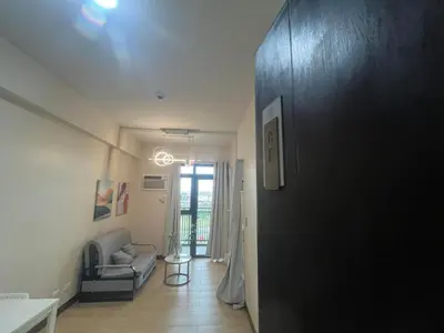 a hallway with a door open to a living room at Moa Gentry Manor WIFI TV Balcony with view Beside Okada in Manila