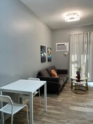 a living room with a couch and a table at Moa Gentry Manor WIFI TV Balcony with view Beside Okada in Manila