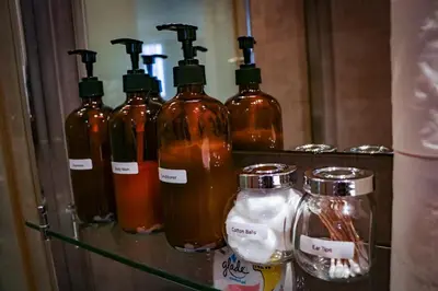 a group of bottles of alcohol sitting on a shelf at Snug Stay in Gramercy Makati with City Skyline View! in Manila