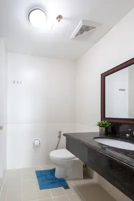 a bathroom with a sink and a toilet and a mirror at NEW 2BR Family Home with FREE Parking & Fiber Wi-Fi in Manila