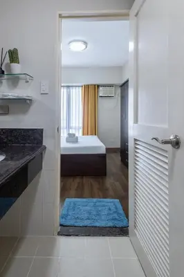 a bathroom with a shower with a blue rug at NEW 2BR Family Home with FREE Parking & Fiber Wi-Fi in Manila