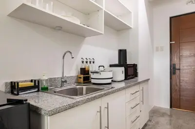 a kitchen with a sink and a microwave at Kael Studio in Manila