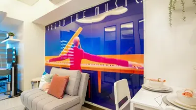 a living room with a wall mural of a roller coaster at Best 1BR in Uptown BGC - Near Mitsukoshi & Malls in Manila