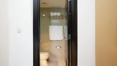 a bathroom with a toilet and a towel at Best 1BR in Uptown BGC - Near Mitsukoshi & Malls in Manila