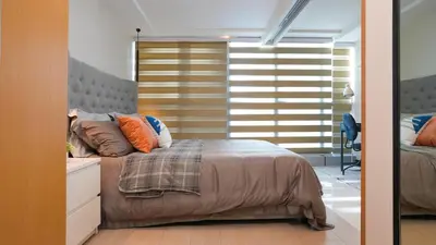 a bedroom with a bed with orange pillows on it at Best 1BR in Uptown BGC - Near Mitsukoshi & Malls in Manila