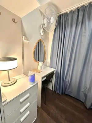 a dressing room with a desk and a fan at Comfy Makati Condo Wifi, Netflix and Disney in Manila