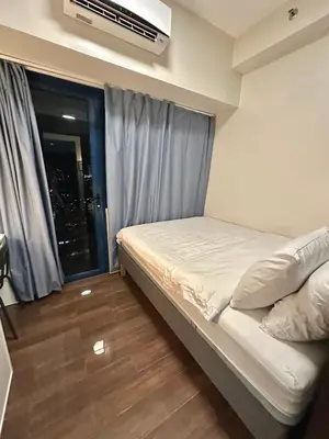 a small bedroom with a bed and a window at Comfy Makati Condo Wifi, Netflix and Disney in Manila