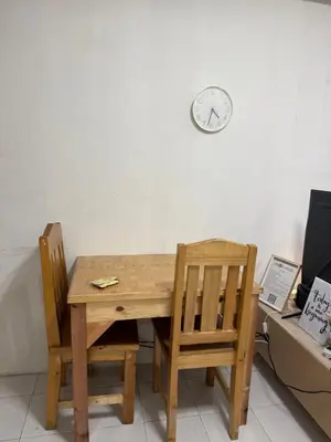 a wooden table with two chairs and a clock on the wall at At Home in Santa Rosa in Santa Rosa