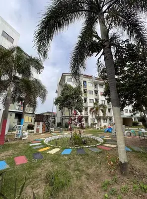 a park with a palm tree and a large building at At Home in Santa Rosa in Santa Rosa