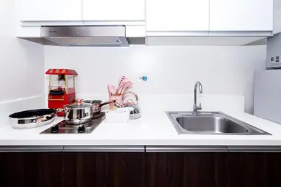 a kitchen counter top with a sink and a stove at Condo in Makati Staycation in Manila