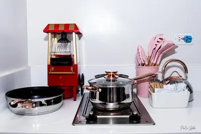 a kitchen stove with a pot and pans on it at Condo in Makati Staycation in Manila