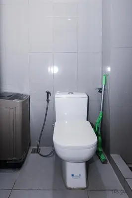 a bathroom with a white toilet and a green vacuum at Condo in Makati Staycation in Manila