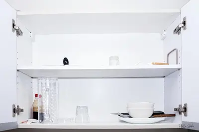 a white shelf with a bowl and dishes on it at Condo in Makati Staycation in Manila